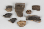 Přeslen a drobné zlomky keramiky ze starší doby železné a fragment raně středověké nádoby zdobené několikanásobnou rytou vlnicí. Foto I. Kyncl, ©  MMP.